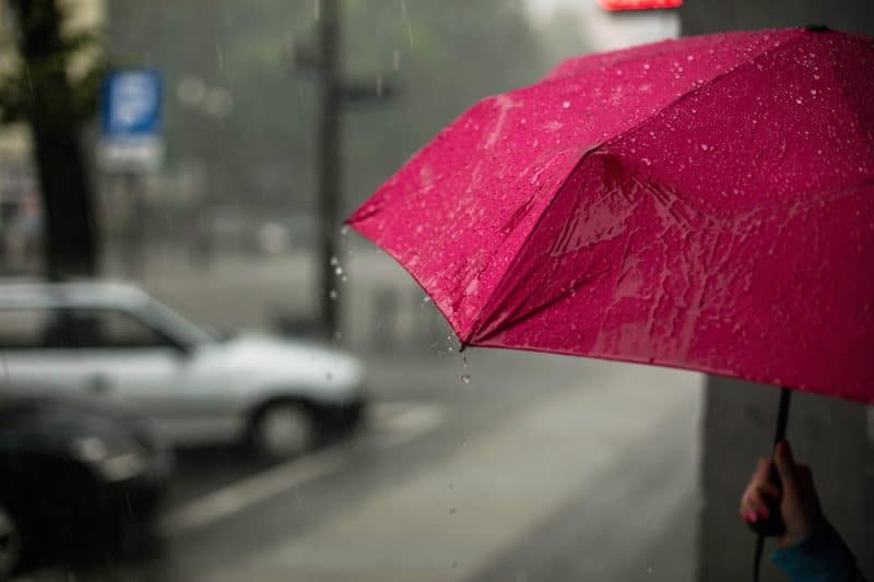 Red umbrella in rainy road