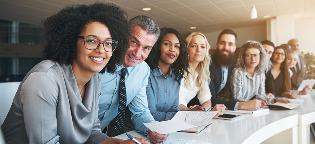 Mixed group of staff workers looking at camera