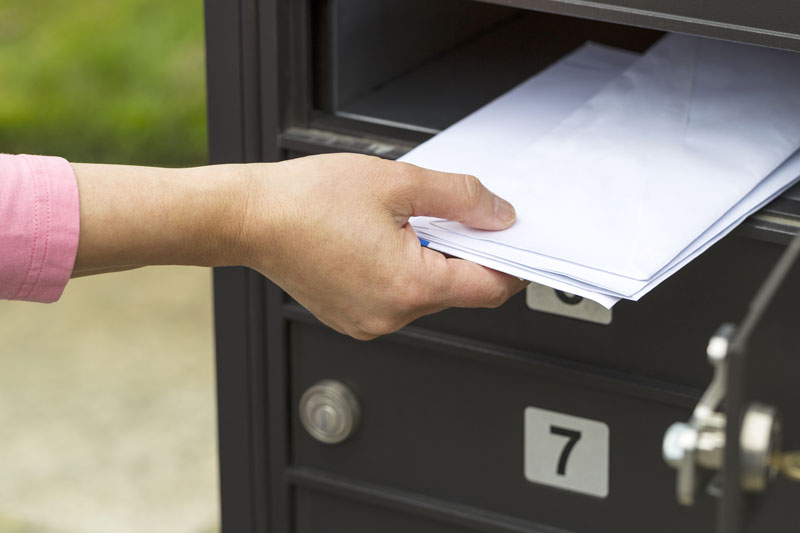 lady putting letters in mailbox