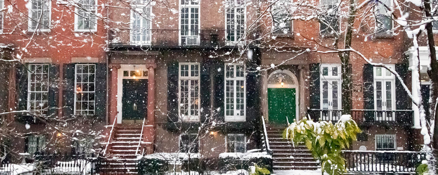 Brick row homes covered in snow representing homeowners or condo insurance coverage