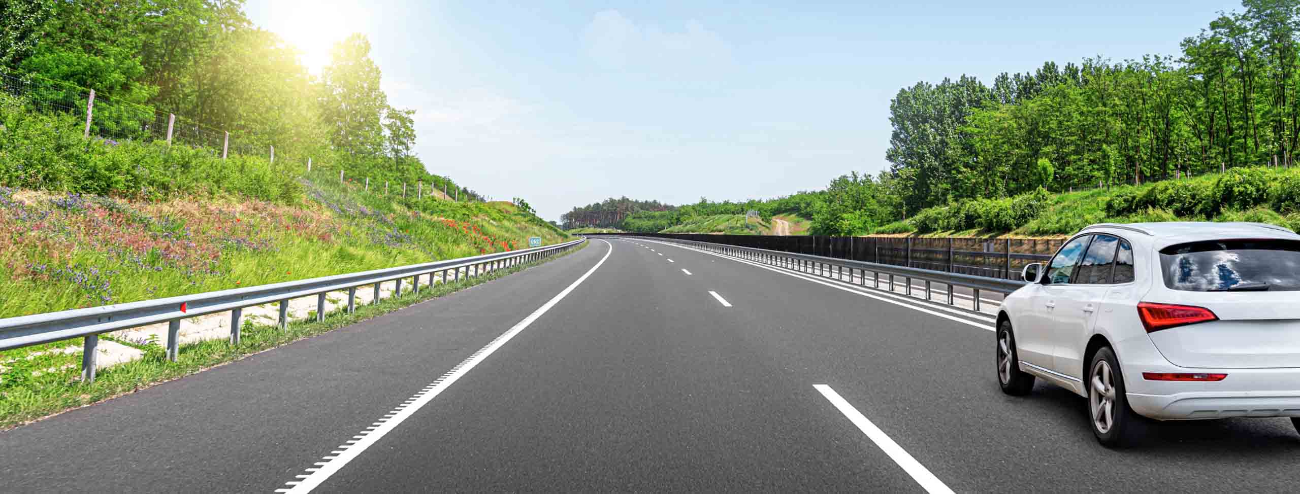 a white car driving on the spring road